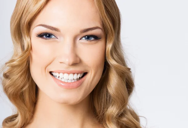 Jovem mulher sorridente alegre, em cinza — Fotografia de Stock