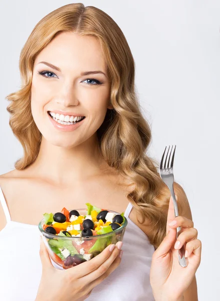 Vrouw met vegetarische salade, over grijs — Stockfoto