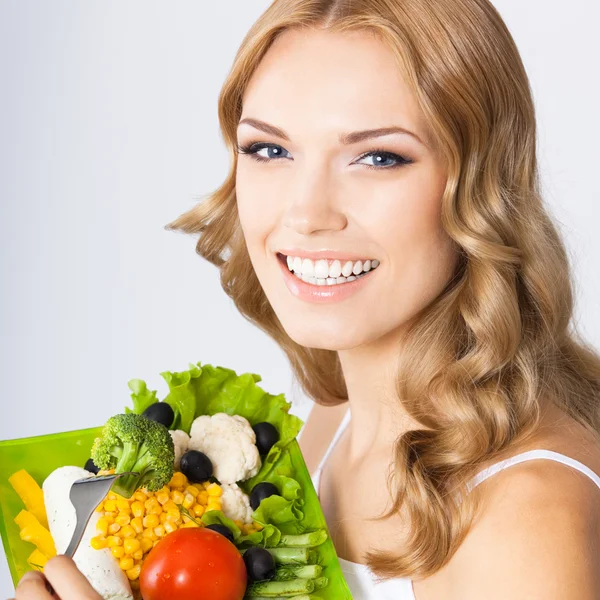 Femme avec salade végétarienne, sur gris — Photo