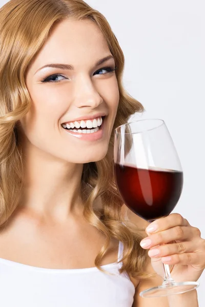 Giovane donna felice con bicchiere di vino rosso, su grigio — Foto Stock