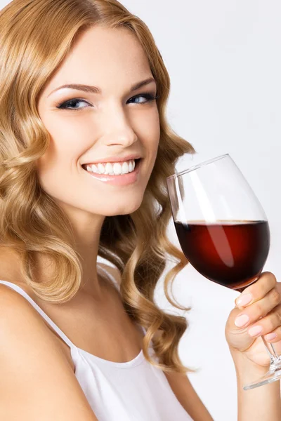 Jovem mulher feliz com copo de vinho tinto, em cinza — Fotografia de Stock