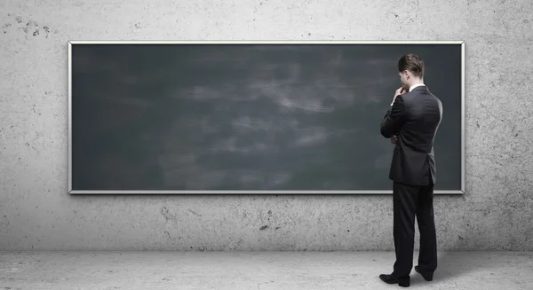 Man op zoek naar blackboard — Stockfoto