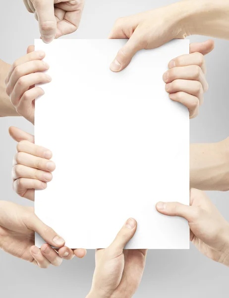 Many hands holding paper — Stock Photo, Image