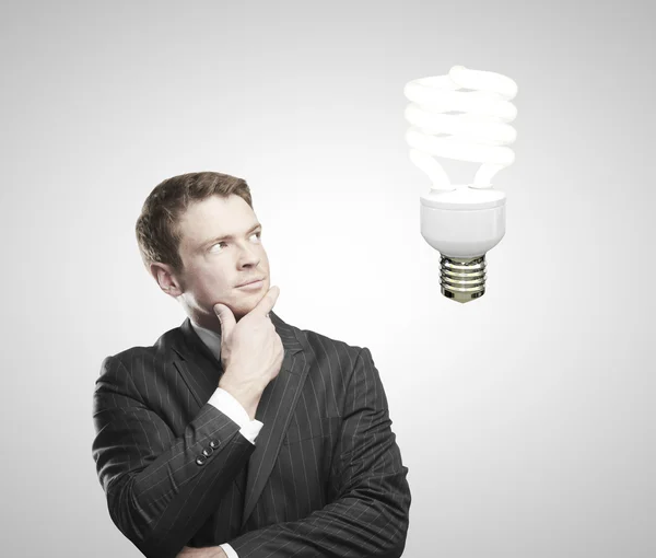 Hombre mirando en la lámpara de ahorro de energía — Foto de Stock