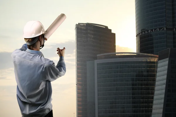 Costruttore che punta al grattacielo — Foto Stock