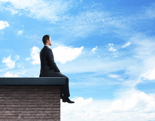 Бизнесмен сидит на крыше — стоковое фото