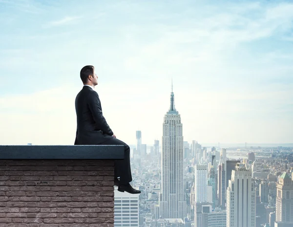 Empresário sentado no telhado — Fotografia de Stock