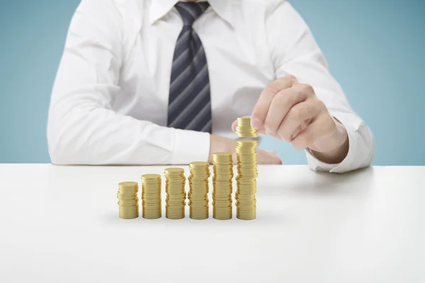 Businessman puts coins — Stock Photo, Image