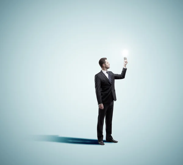 Businessman holding lamp — Stock Photo, Image