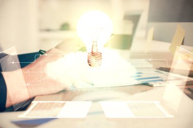 Dijital bir cihaz ve ampul hologram çizimi kullanarak insanın ellerini tutarken çift pozlama. Fikir kavramı.