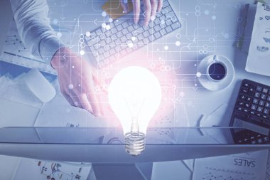 Bilgisayar klavyesi ve ampul hologramı çizimlerinin üzerine iki kez yazı yazan bir adamın eline maruz kalmak. Üst Manzara. Fikir kavramı.