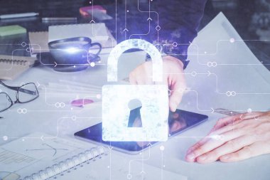 Dijital bir cihaz ve kilit çizimi kullanan bir adamın el ele tutuşması. Güvenlik kavramı.