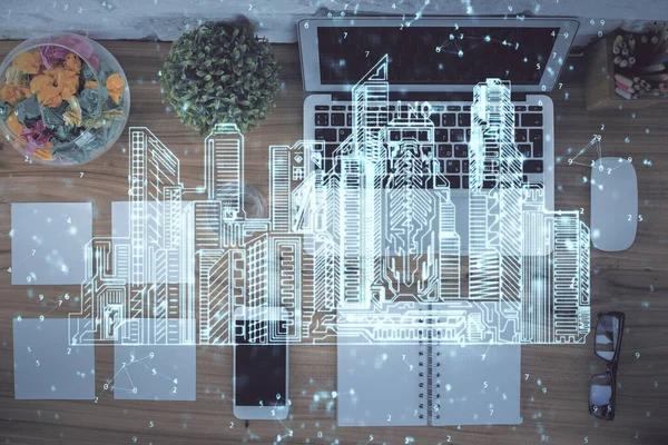 City drawing over computer on the desktop background. Top view. Double exposure. Smart home concept.