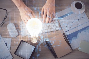 Bilgisayar klavyesi ve ampul hologramı çizimlerinin üzerine iki kez yazı yazan bir adamın eline maruz kalmak. Üst Manzara. Fikir kavramı.