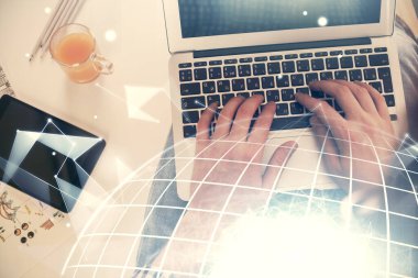Bilgisayar klavyesine ve dünya haritası hologramına yazı yazan bir adamın eline çok kez maruz kalmış. Üst Manzara. Teknoloji konsepti.