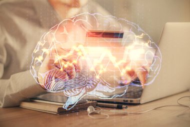 Kredi kartı ve beyin temalı çizimlerle bilgisayarda yazarken çift pozlama. E-ticaret ve yapay zeka kavramı.