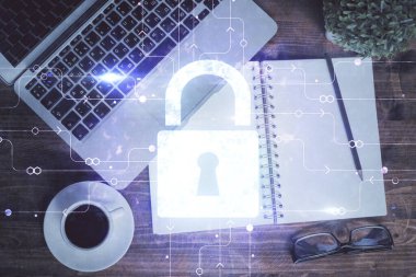 Bilgisayarla çalışma masası arkaplanının üzerine iki kat kilit hologramı çiziliyor. Veri güvenliği kavramı. Üst görünüm.