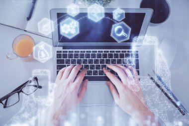 Bilgisayar klavyesinin ve teknik temalı hologram çiziminin üzerine yazarken iki kez görüntülenmiş. Üst Manzara. Teknoloji konsepti.