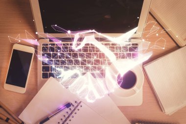 Masaüstü arka planında bilgisayarın üzerinden el sıkışma çizimi. Üst Manzara. Çifte maruziyet. Ortaklık kavramı.