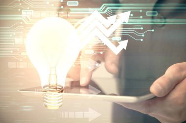 Dijital bir cihaz ve ampul hologram çizimi kullanarak insanın ellerini tutarken çift pozlama. Fikir kavramı.