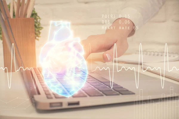 コンピュータと心臓のホログラム図面に入力する女性の手の二重露出 教育理念 — ストック写真