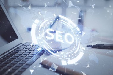 SEO yazılarını ve masaüstünü kahve ve masa arkasında eşyalar eşliğinde iki kez görüntüle. Arama optimizasyonu kavramı.