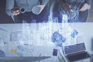 Kadın ve erkeğin birlikte çalıştığı ve binaların hologram çizimlerinin çifte pozlanması. Bilgisayar arkaplanı. Üst Manzara. Akıllı şehir konsepti.