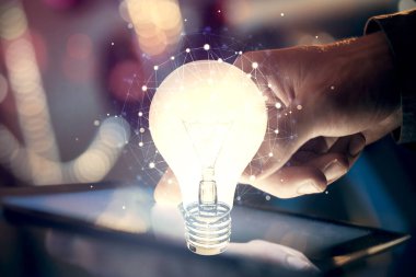 Dijital bir cihaz ve ampul hologram çizimi kullanarak insanın ellerini tutarken çift pozlama. Fikir kavramı.