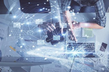 Birlikte çalışan kadın ve erkeğin çifte pozu ve hologram çizimi. Bilgisayar arkaplanı. Üst Manzara. Elektronik posta kavramı.