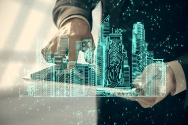 Dijital bir cihaz ve şehir çizimi kullanarak insanın ellerini tutarken çift pozlama.