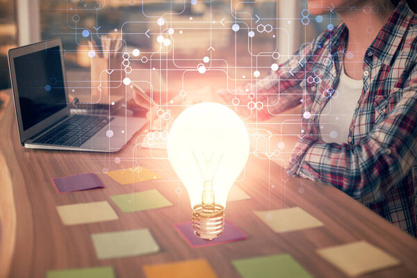 Double exposure of woman hands typing on computer and light bulb drawing. Idea concept.