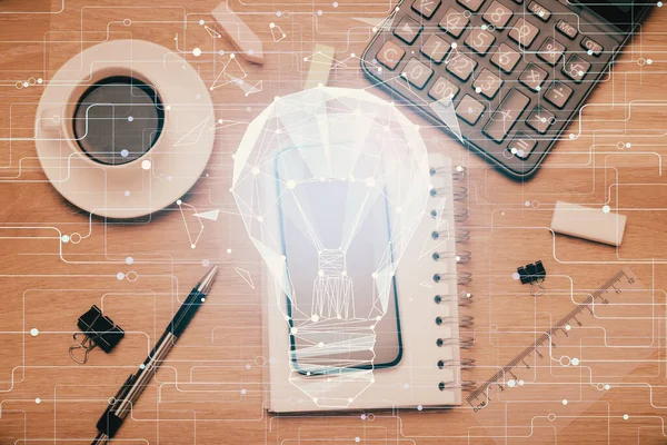 Ampulü telefonla masanın üzerine çizerken çift pozlama. Üst Manzara. Fikir kavramı.