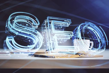 SEO yazılarını ve masaüstünü kahve ve masa arkasında eşyalar eşliğinde iki kez görüntüle. Arama optimizasyonu kavramı.