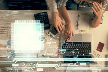 Kadın ve erkeğin birlikte çalışması ve veri temalı hologram çizimi. Bilgisayar arkaplanı. Üst Görünüm.