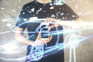 Dijital bir cihaz ve otomobil temalı hologram çizimi kullanarak insanın elini tutarken çift pozlama. Teknoloji konsepti.