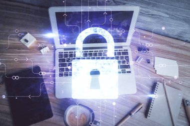 Bilgisayarla çalışma masası arkaplanının üzerine iki kat kilit hologramı çiziliyor. Veri güvenliği kavramı. Üst görünüm.