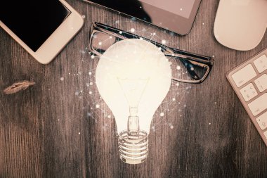 Ampulü telefonla masanın üzerine çizerken çift pozlama. Üst Manzara. Fikir kavramı.