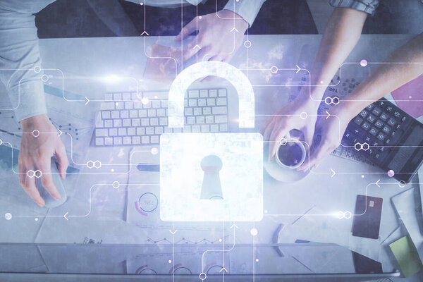 Double exposure of man and woman working together and lock hologram drawing. Security concept. Computer background. Top View.