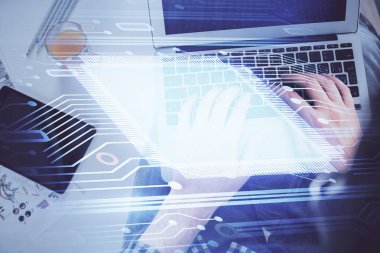 İnsan elinin bilgisayar klavyesi ve veri temalı hologram çiziminin üzerine yazarken çoklu pozlama. Üst Manzara. Teknoloji konsepti.