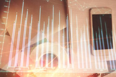 Forx grafik hologramının telefonlu masaüstü üzerinde çoklu pozlandırılması. Üst Manzara. Mobil ticaret platformu kavramı.