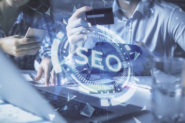 Bir kredi kartı ve SEO hologramı çizimi tutan kadın ve erkeğin online alışverişine iki kez maruz kalıyorlar. arama optimizasyonu E-ticaret ödeme çevrimiçi konsept.