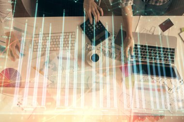 Birlikte çalışan kadın ve erkeğin birden fazla pozu ve finansal grafik hologramı. İş konsepti. Bilgisayar arkaplanı.