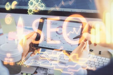 Dijital bir cihaz ve seo çizimi kullanan bir adamın el ele tutuşması. arama optimizasyonu kavramı.