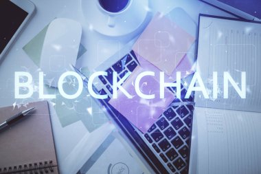 Masaüstü arkaplanındaki bilgisayarın üzerinden engelleme temalı hologram çizimleri. Üst Manzara. Çoklu maruz kalma. Kripto ekonomi kavramı.