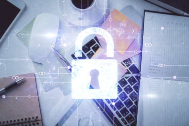 Bilgisayarla çalışma masası arkaplanının üzerine iki kat kilit hologramı çiziliyor. Veri güvenliği kavramı. Üst görünüm.