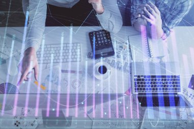 Kadın ve erkeğin birlikte çalışması ve finansal grafik hologramı çizimi. Pazar analizi konsepti. Bilgisayar arkaplanı. Üst Görünüm.
