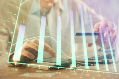 Ellerinde kredi kartı ve forex çizimi olan bir adamın çift pozu. İnternet E-ticaret kavramında hisse senedi ve dijital fintech.