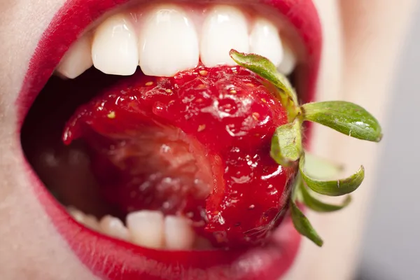 Jordbær i munden - Stock-foto