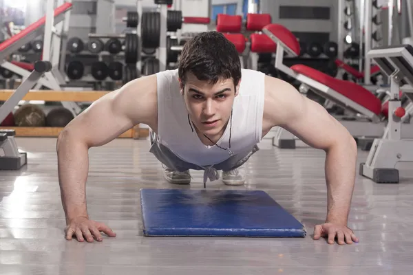 Strong handsome man exercising at the gym — Stock Photo, Image