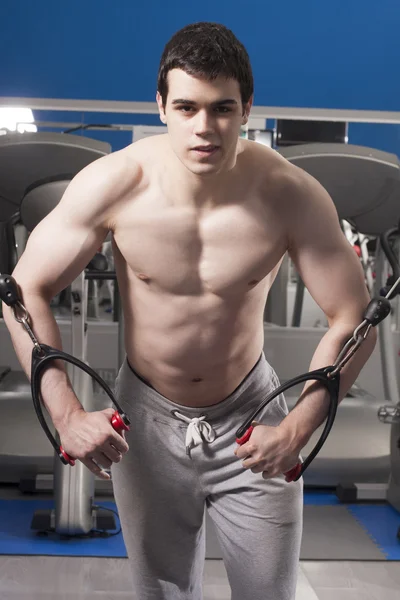 Hombre guapo fuerte haciendo ejercicio en el gimnasio — Foto de Stock